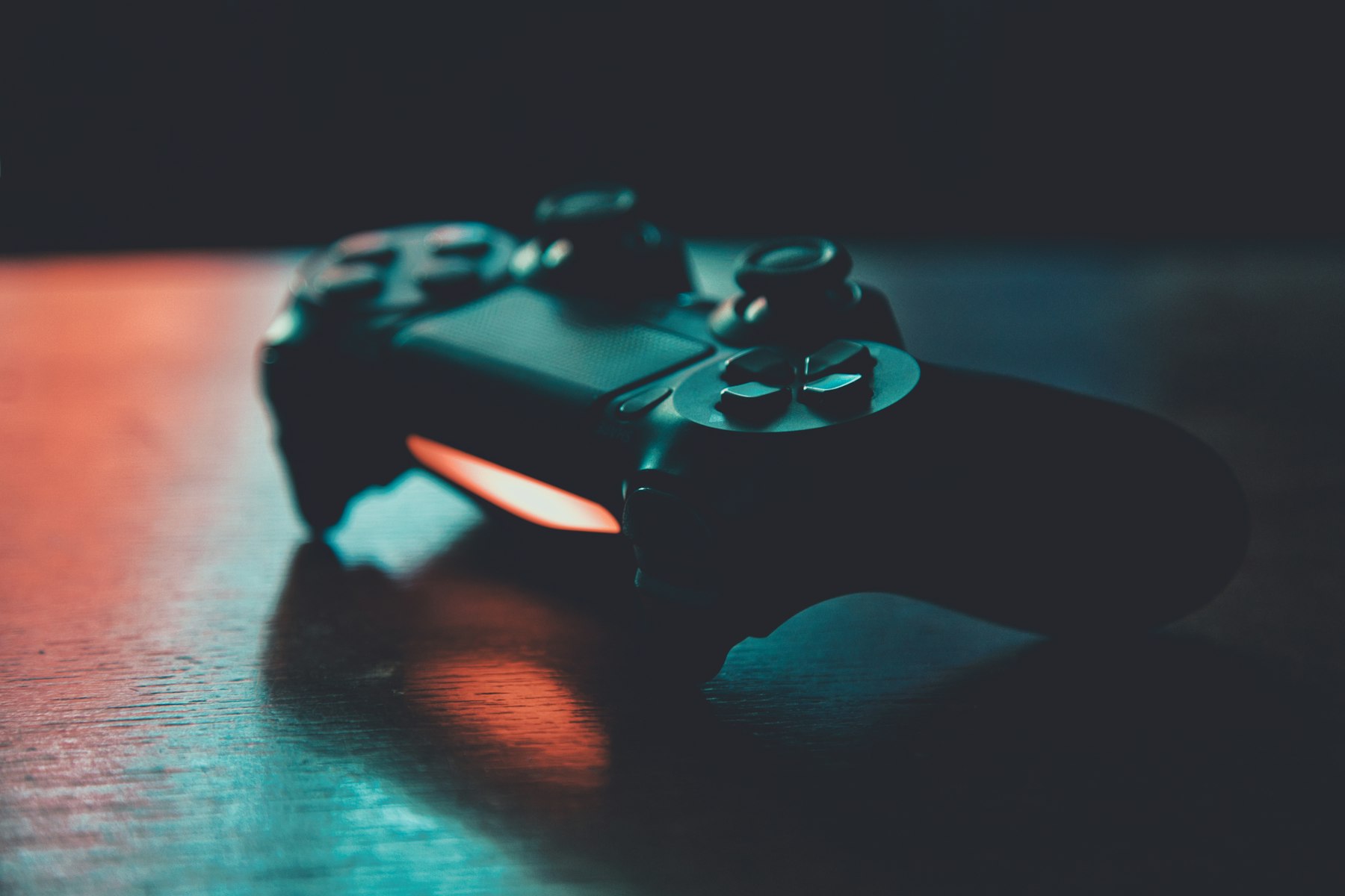 Schwarzer Controller auf Holz in blauem und orangem Licht
