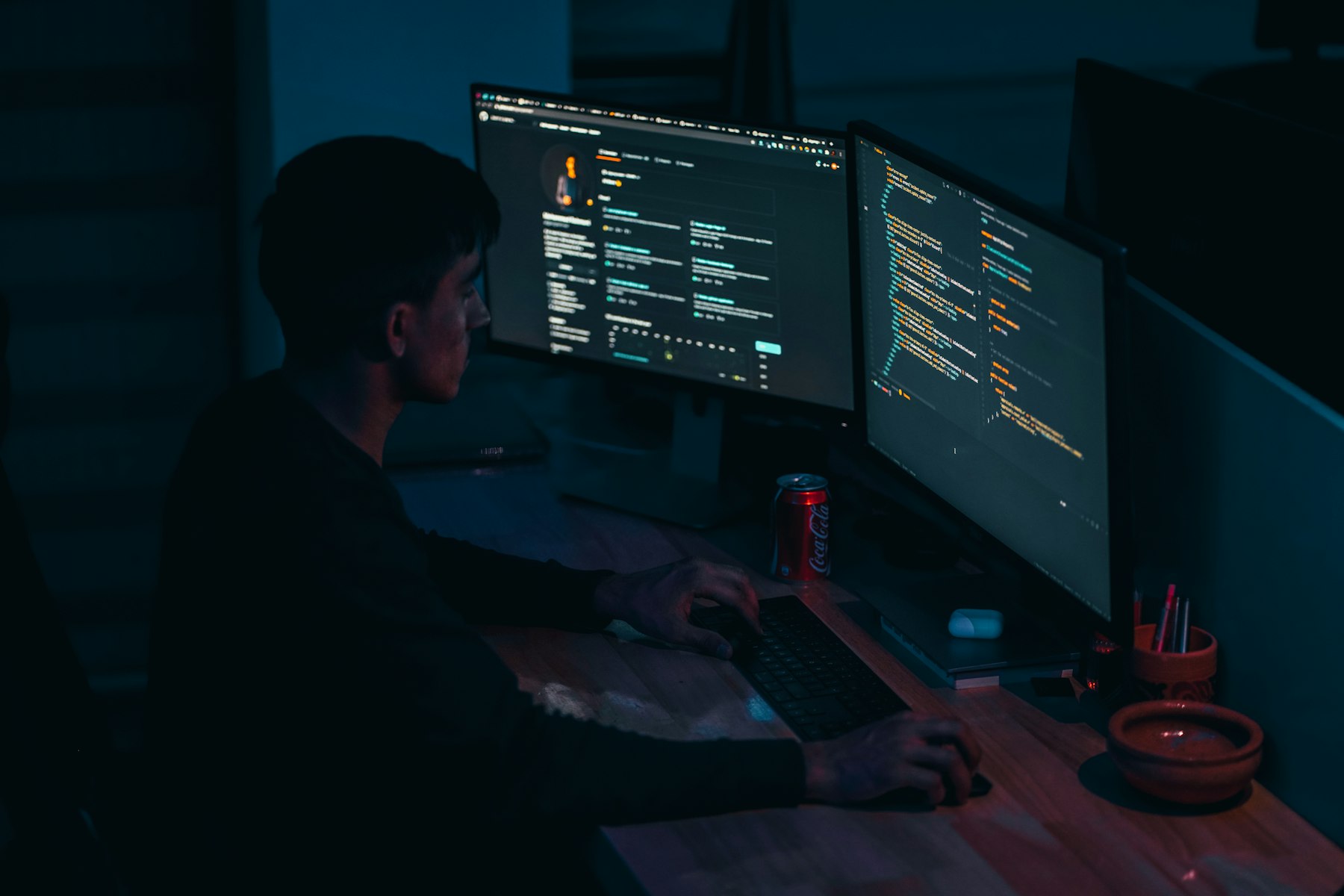 Mann im schwarzen Pullover arbeitet am Computer