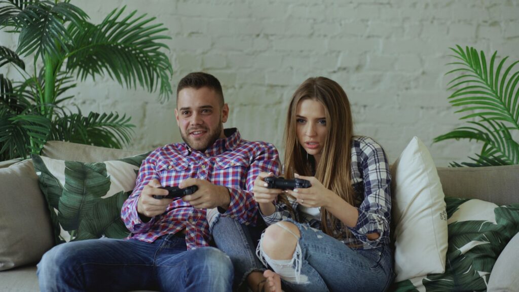 Paar spielt gemeinsam Videospiele auf dem Sofa