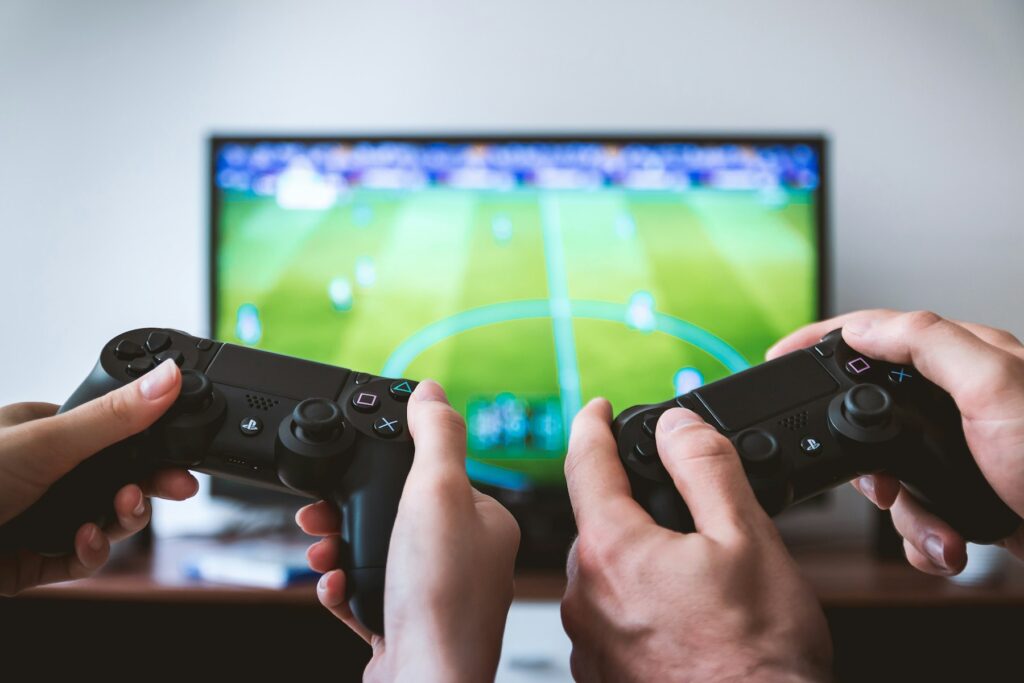 Zwei Personen spielen an einer PlayStation-Konsole