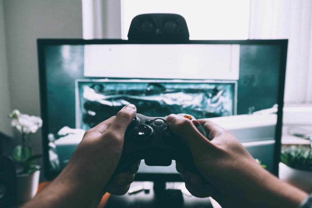 Person hält einen Controller vor einem Fernseher