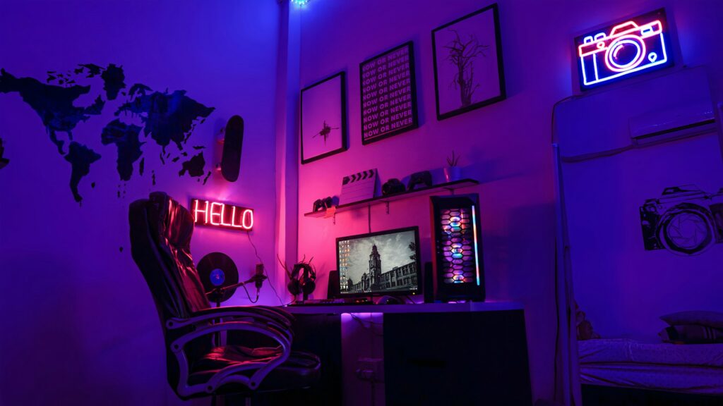 Gaming-Arbeitsplatz mit Computer und Neonschildern in violettem Licht
